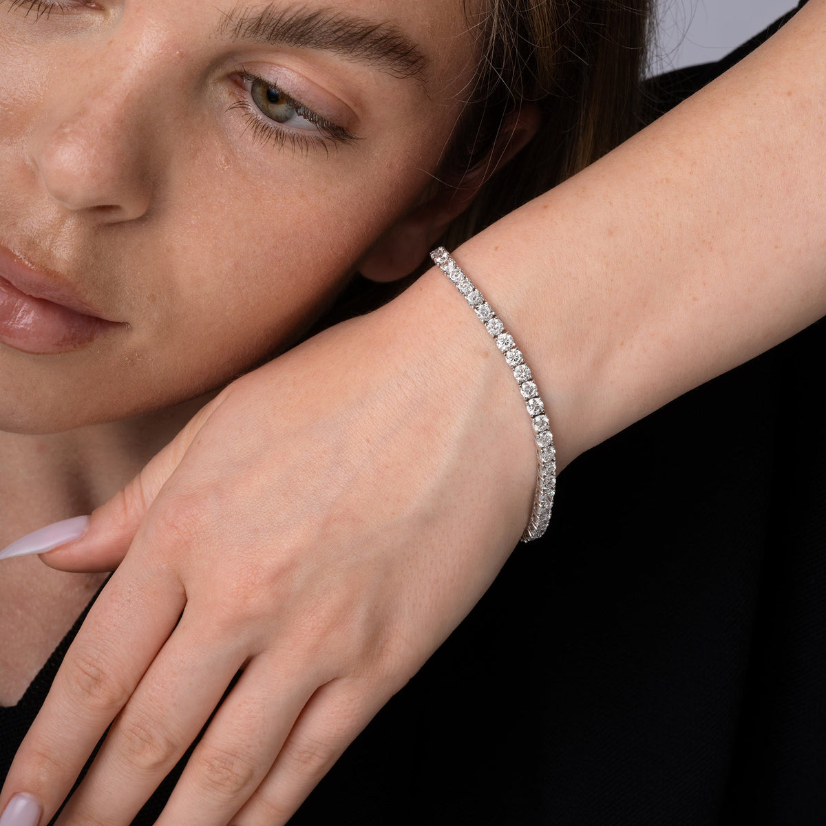 Round diamond tennis bracelet worn on the wrist, 5.30 carat total weight