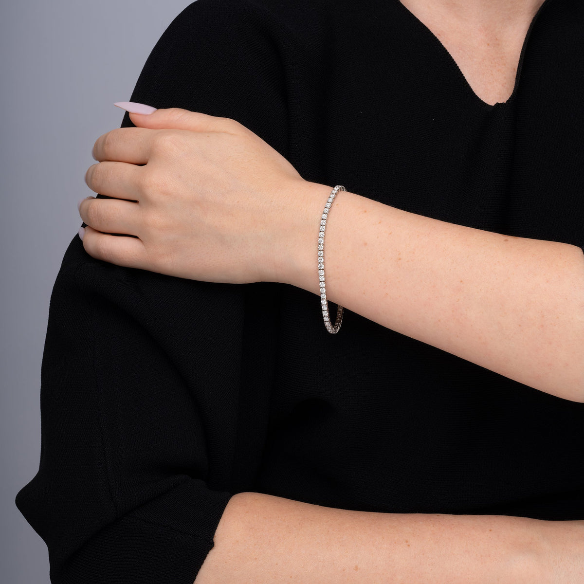 Model wearing a round diamond tennis bracelet, second angle