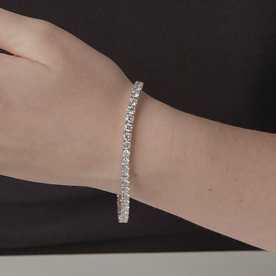 Round diamond tennis bracelet shown in motion on the wrist