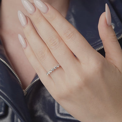 Round diamond half eternity band shown in motion on the hand