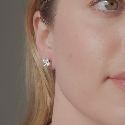 Round diamond stud earrings shown in motion on the ear, 4.14 carat total weight