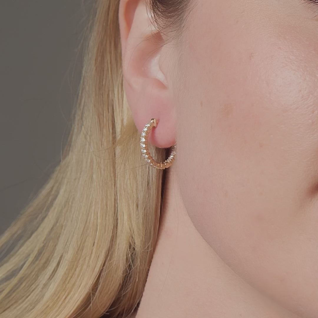Diamond hoop earrings shown in motion on the ear