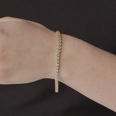 Bezel set diamond tennis bracelet shown in motion, 14K yellow gold #Metal_Yellow Gold