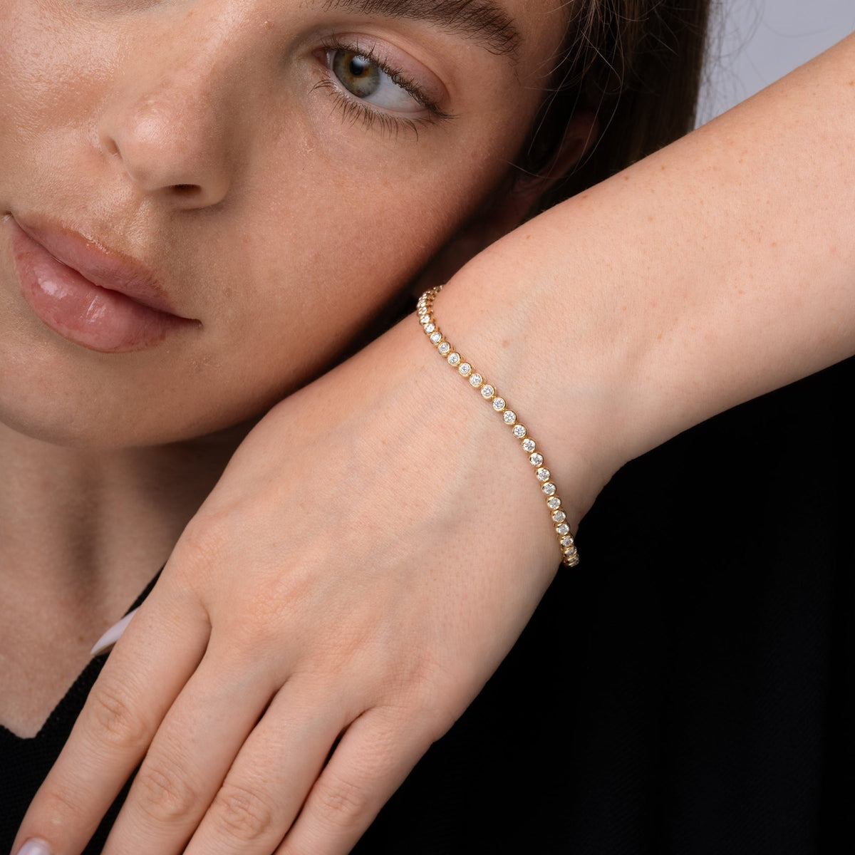 Bezel set diamond tennis bracelet worn on the wrist in 14K yellow gold #Metal_Yellow Gold