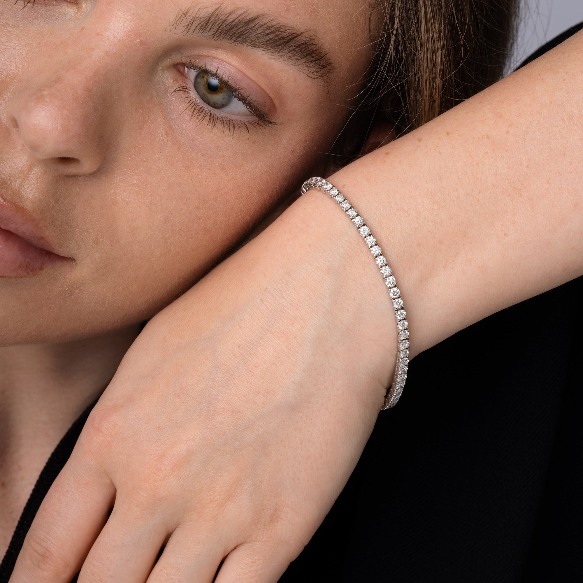 Round diamond tennis bracelet worn on the wrist, 10.23 carat total weight