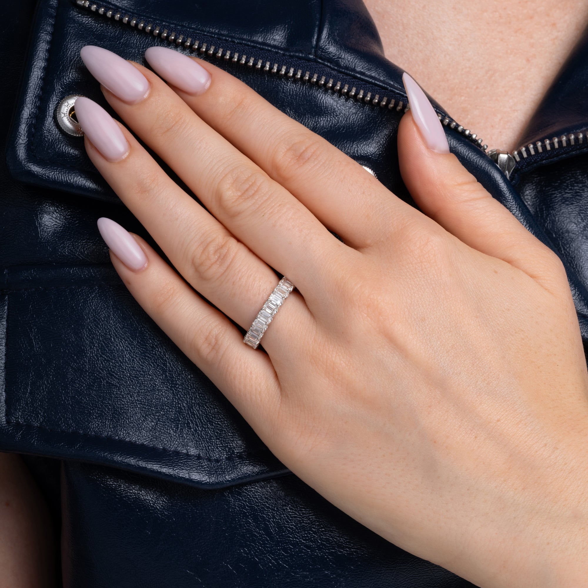 3.43 carat emerald cut east-west band shown on the finger